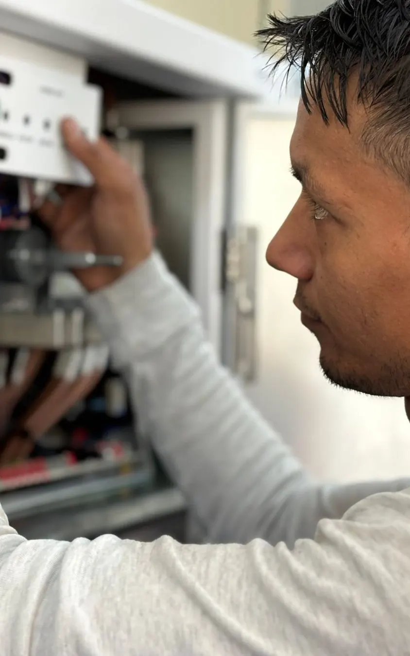 Électricien contrôlant les disjoncteurs d'un tableau électrique
